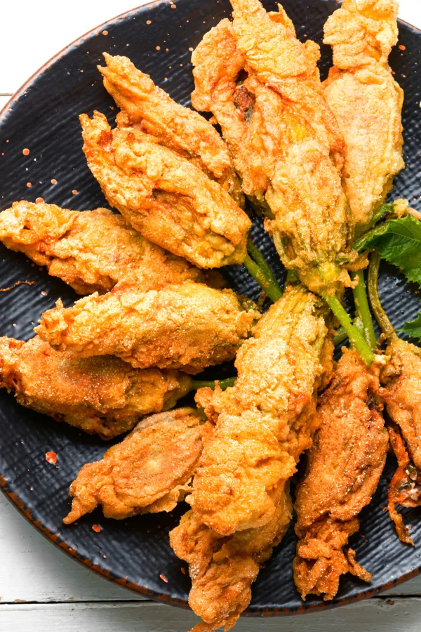 fried and stuffed zucchini blossoms on a plate