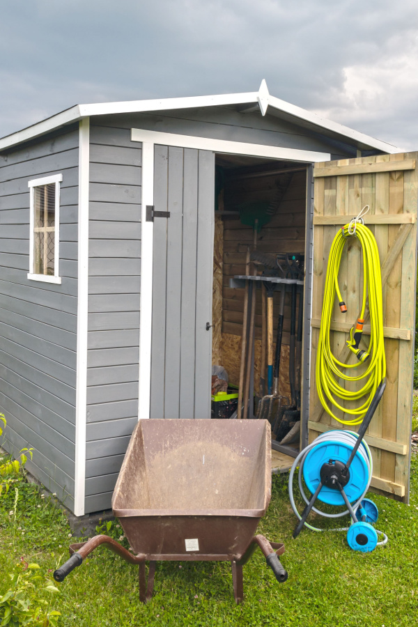 An unheated shed with garden equipment. 