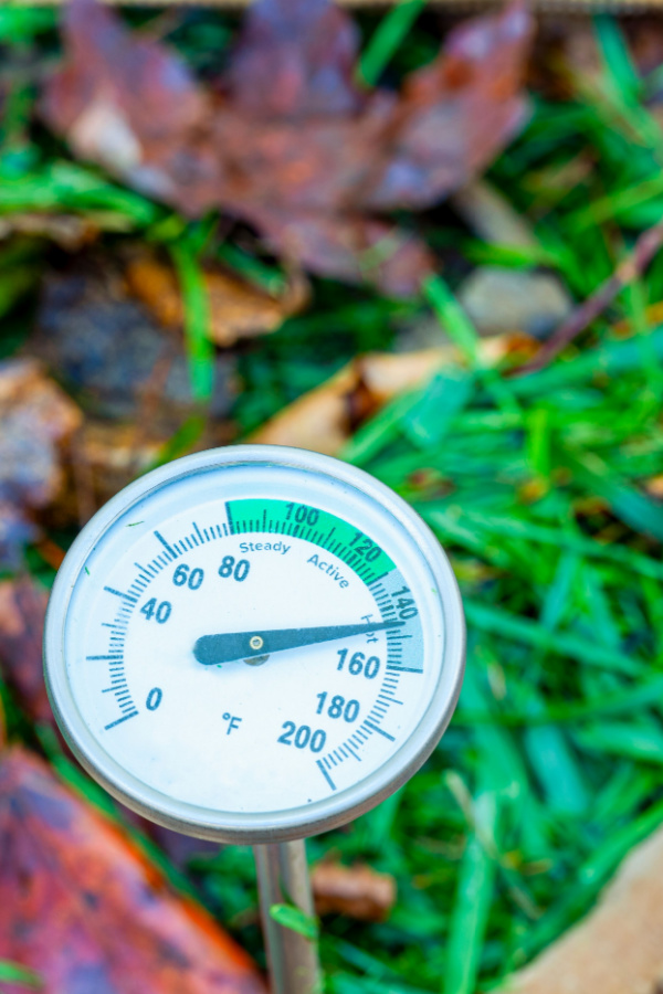 A compost thermometer in a pile of fresh compost