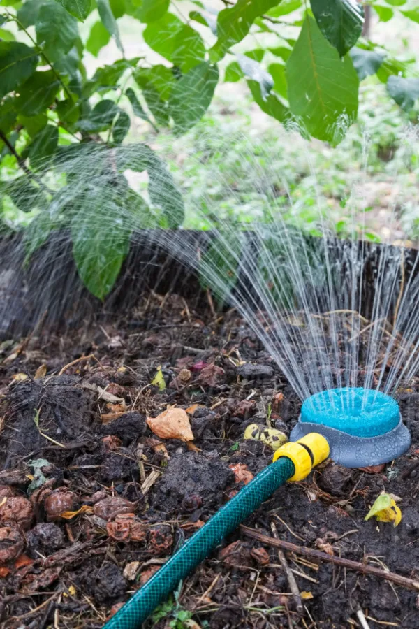 A sprinkler watering a home pile. 