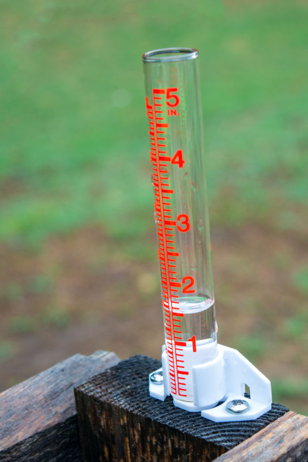 A rain gauge with an inch and a half of water in it.