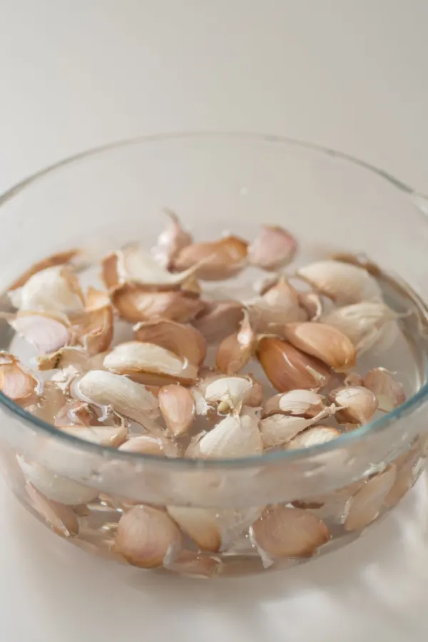 A bowl of garlic cloves soaking in water.